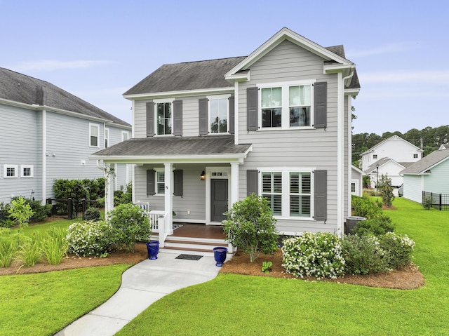 3998 Capensis Ln, Ravenel, SC 29470 - view of front facade featuring covered porch, a front lawn, and a shingled roof