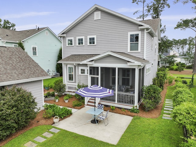 3998 Capensis Ln, Ravenel, SC 29470 - back of property featuring a sunroom, a patio, roof with shingles, and a lawn