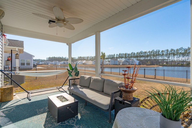 view of patio / terrace with an outdoor hangout area, a water view, fence, and a ceiling fan