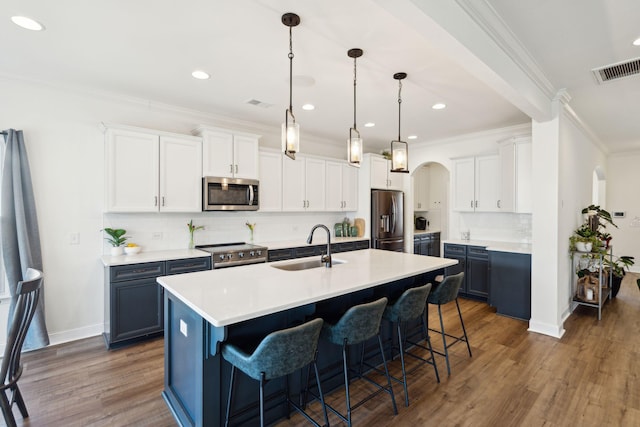 kitchen featuring blue cabinetry, white cabinetry, stainless steel appliances, and light countertops