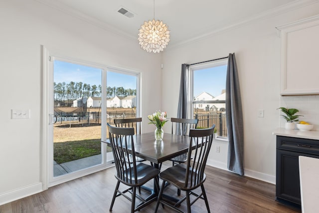 dining room with visible vents, dark wood-type flooring, and a wealth of natural light