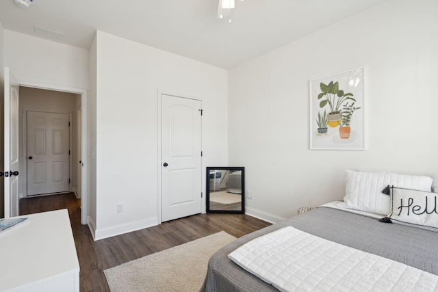 bedroom with dark wood-style flooring and baseboards