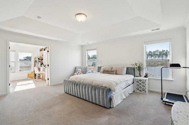 carpeted bedroom featuring crown molding, a tray ceiling, visible vents, and baseboards