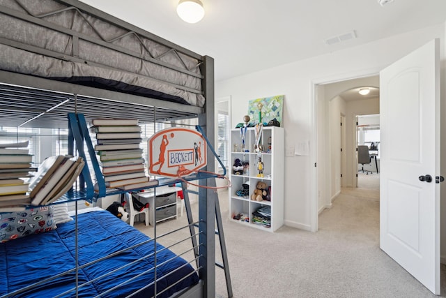 bedroom featuring arched walkways, carpet floors, visible vents, and baseboards