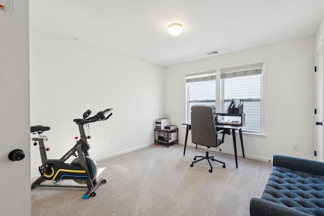 office area featuring baseboards, visible vents, and light colored carpet