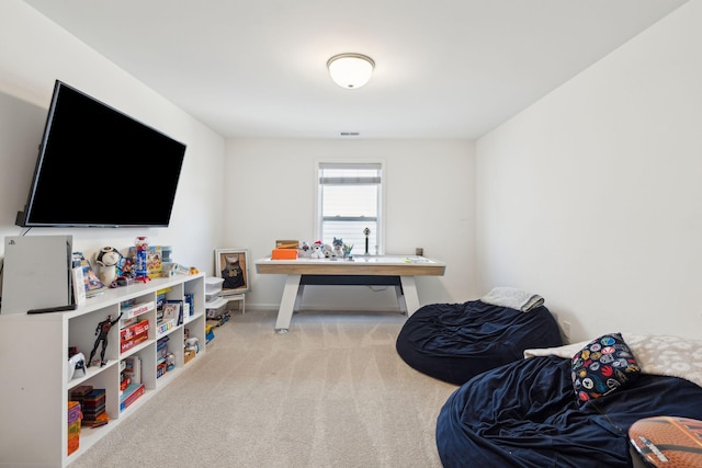 recreation room featuring light carpet and baseboards