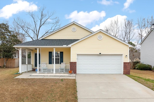 view of front of home featuring a garage, a front yard, and covered porch