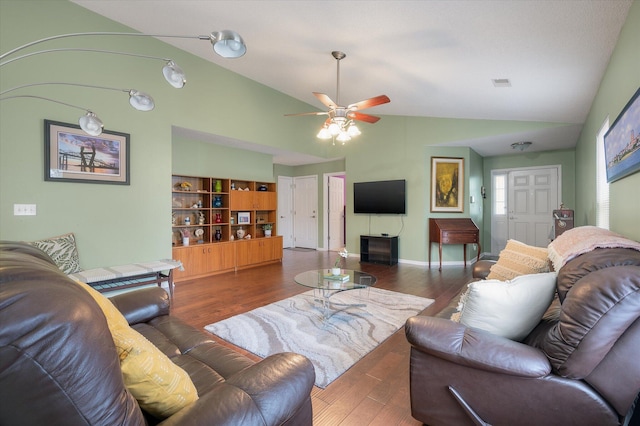 living room with dark wood-type flooring, ceiling fan, and vaulted ceiling