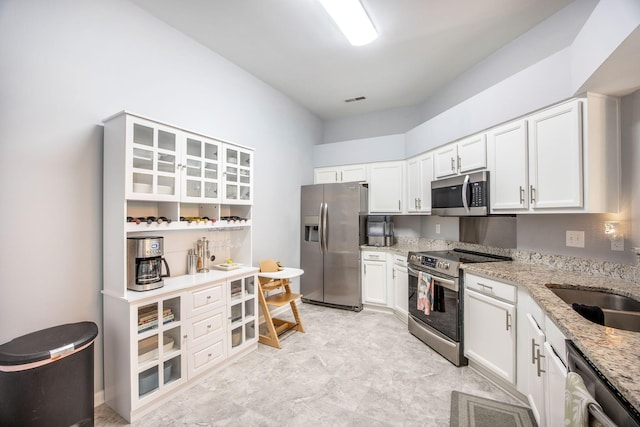 512 Castle Hall Rd, Mount Pleasant, SC 29464 - kitchen featuring stainless steel appliances, light stone counters, white cabinetry, and glass insert cabinets