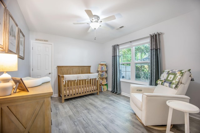 512 Castle Hall Rd, Mount Pleasant, SC 29464 - bedroom with light wood-style flooring, a nursery area, baseboards, and ceiling fan