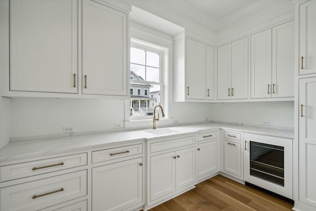 1479 Jeremy Cay Ct, Awendaw, SC 29429 - kitchen featuring a sink, white cabinetry, light stone counters, and wood finished floors