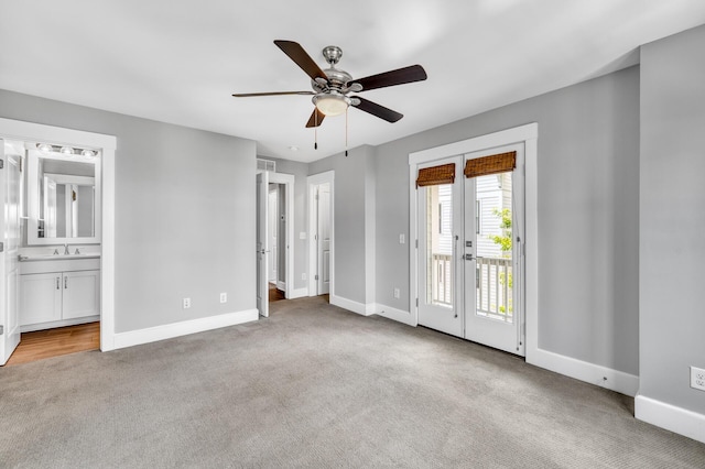 unfurnished bedroom featuring baseboards, carpet, a sink, and access to exterior