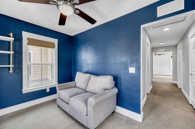 living area with carpet floors, attic access, visible vents, and baseboards