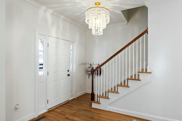 entryway featuring ornamental molding, wood finished floors, visible vents, and stairs