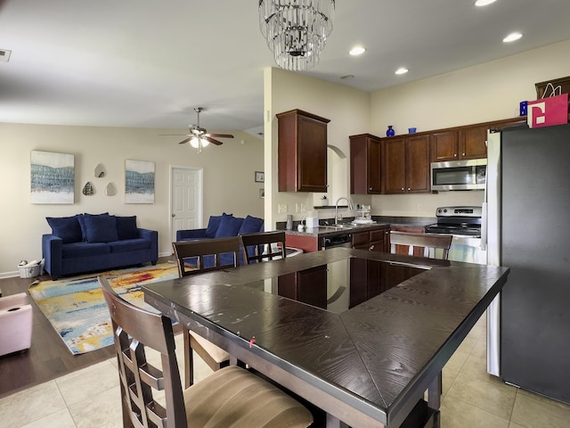 224 Market Hall St, Moncks Corner, SC 29461 - kitchen with appliances with stainless steel finishes, light tile patterned floors, dark countertops, open floor plan, and a ceiling fan