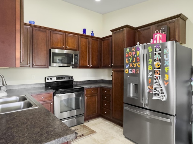 224 Market Hall St, Moncks Corner, SC 29461 - kitchen with stainless steel appliances, a sink, light tile patterned floors, and dark countertops