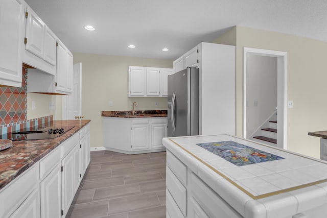 919 Overview Ct, Mount Pleasant, SC 29464 - kitchen with stainless steel fridge with ice dispenser, black electric cooktop, backsplash, tile countertops, and white cabinetry