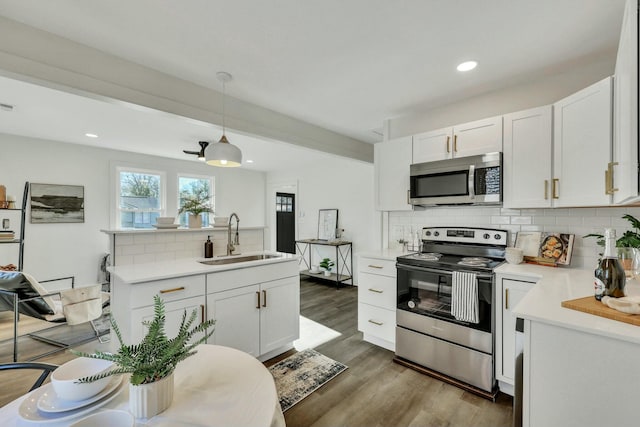 kitchen featuring white cabinets, appliances with stainless steel finishes, sink, and pendant lighting