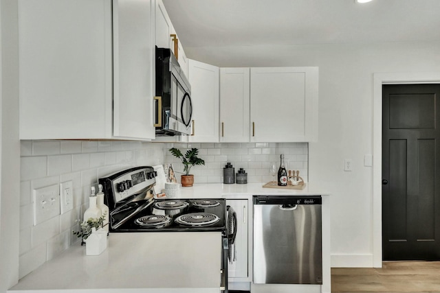 kitchen featuring white cabinets, appliances with stainless steel finishes, light hardwood / wood-style flooring, and tasteful backsplash