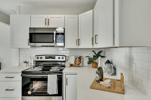 kitchen featuring appliances with stainless steel finishes, white cabinetry, and tasteful backsplash