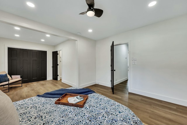 bedroom featuring ceiling fan, a closet, and hardwood / wood-style flooring