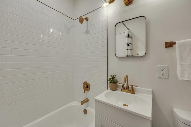 full bathroom with toilet, tiled shower / bath, and vanity