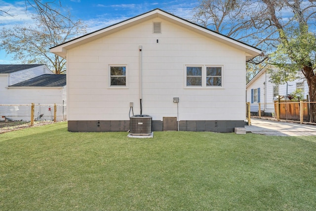 rear view of house featuring a yard, a patio, and central AC