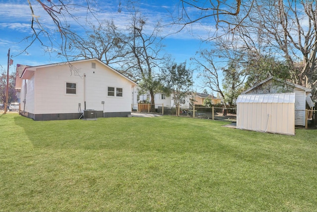 view of yard featuring a storage shed and central air condition unit