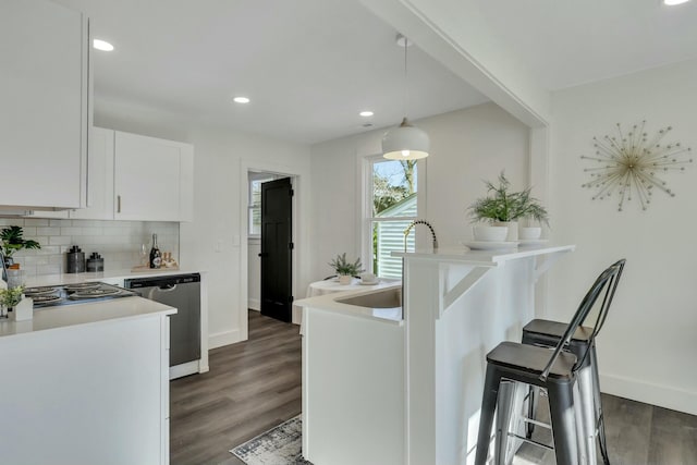 kitchen with backsplash, pendant lighting, stainless steel dishwasher, sink, and white cabinetry