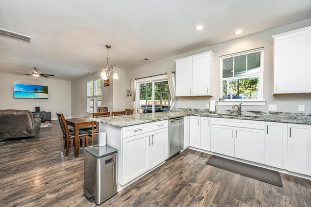 kitchen with kitchen peninsula, stainless steel dishwasher, sink, decorative light fixtures, and white cabinetry