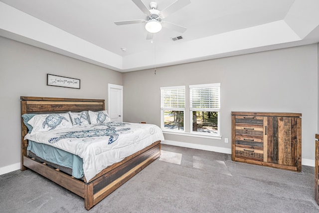 bedroom with carpet floors, a tray ceiling, and ceiling fan