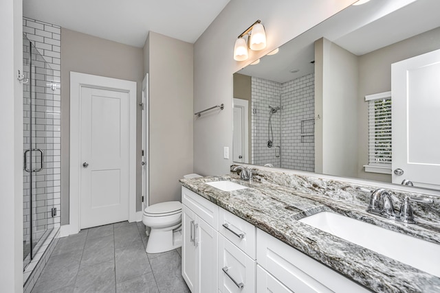 bathroom featuring tile patterned floors, vanity, a shower with shower door, and toilet