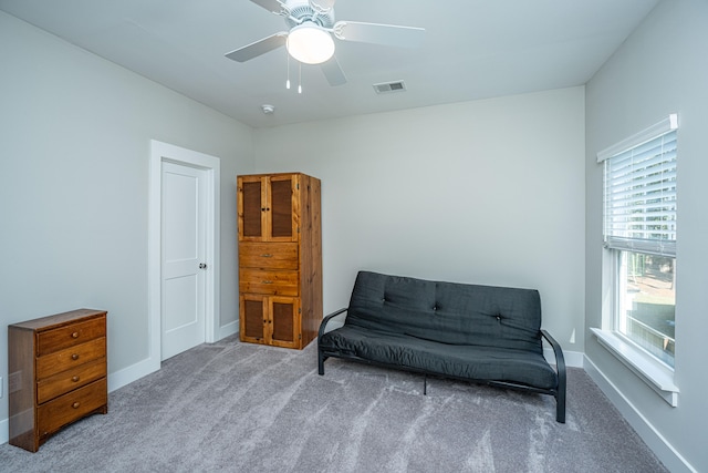 living area featuring ceiling fan and carpet