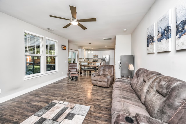 living room featuring dark hardwood / wood-style flooring and ceiling fan