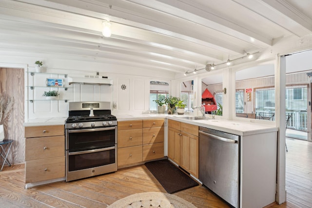 kitchen featuring appliances with stainless steel finishes, beamed ceiling, plenty of natural light, and sink