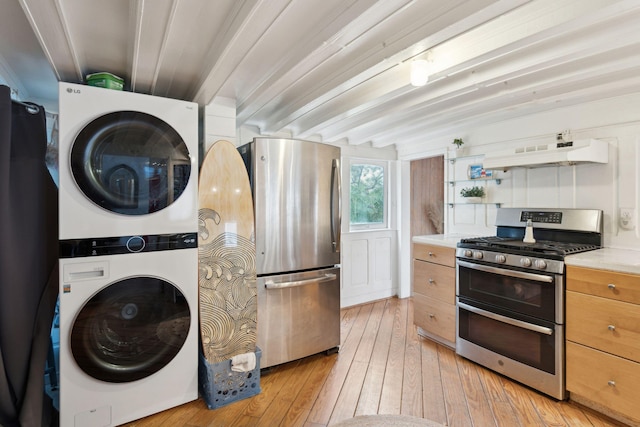 laundry area with stacked washer and dryer and light wood-type flooring