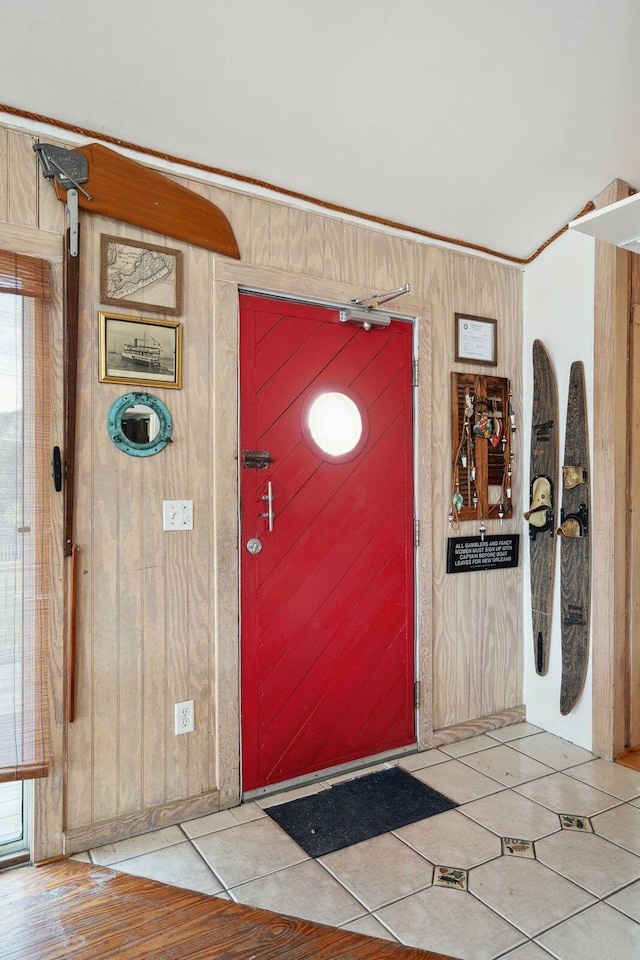 entrance foyer featuring wood walls and crown molding