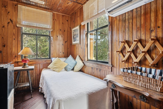 bedroom with a wall unit AC, wooden ceiling, wood walls, and dark hardwood / wood-style floors