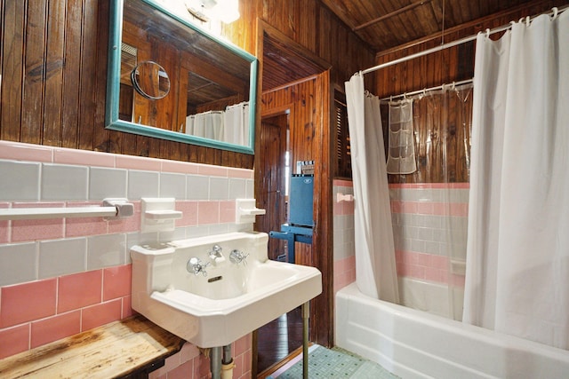 bathroom with wood ceiling, shower / bath combination with curtain, tile walls, sink, and tasteful backsplash