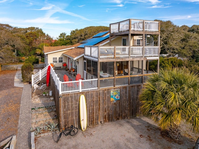 view of front of property featuring solar panels and a balcony