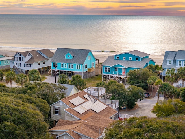 aerial view at dusk featuring a water view