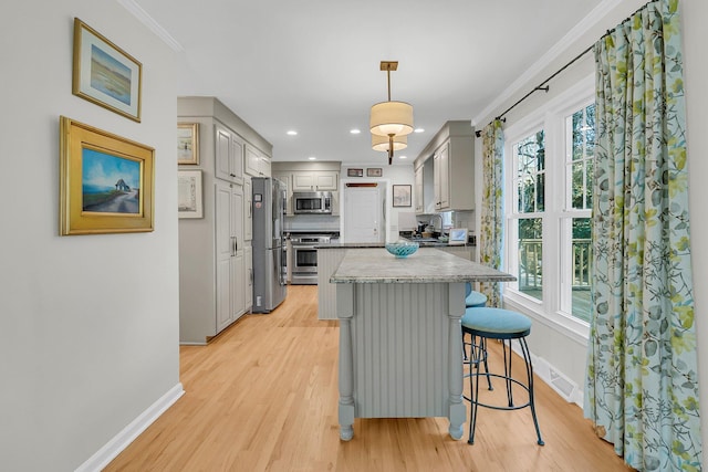 kitchen featuring a healthy amount of sunlight, a kitchen island, stainless steel appliances, and gray cabinetry