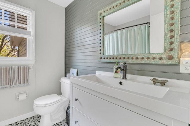 bathroom with baseboards, vanity, and toilet