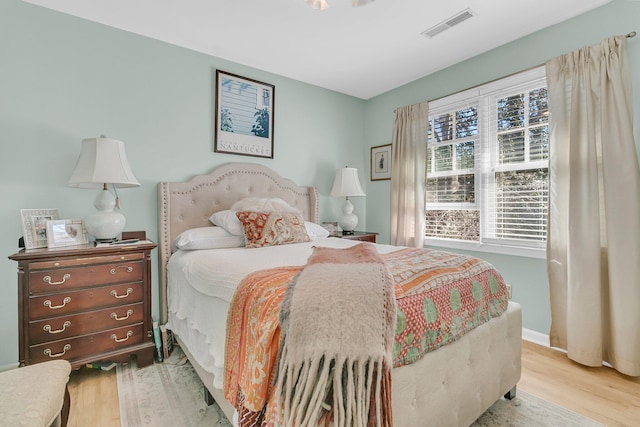 bedroom featuring visible vents, baseboards, and wood finished floors