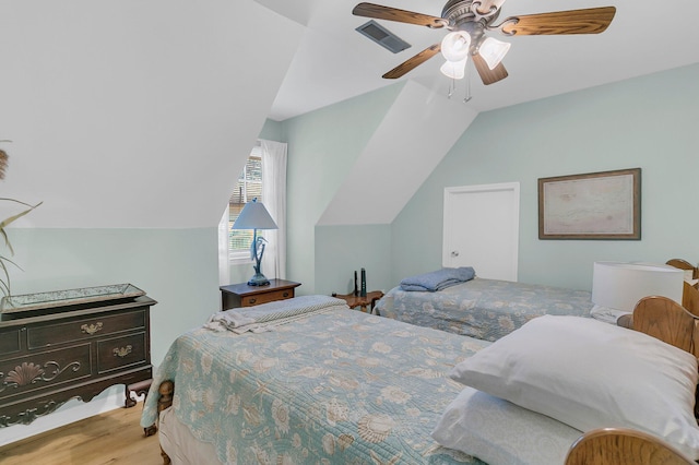 bedroom featuring vaulted ceiling, ceiling fan, wood finished floors, and visible vents