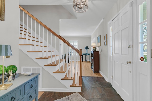 entrance foyer with stairs, crown molding, dark wood-style floors, and baseboards