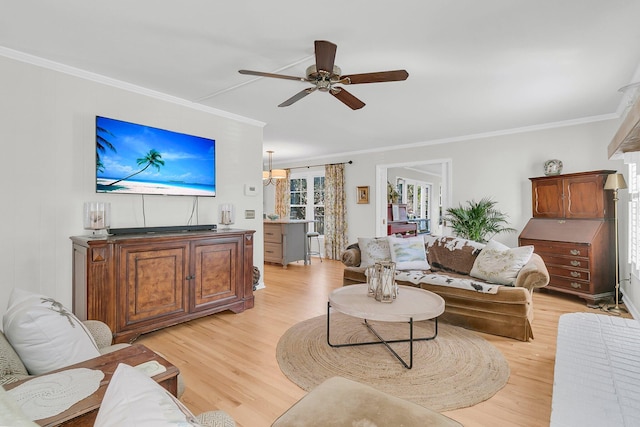 living room with a ceiling fan, crown molding, and light wood-style flooring