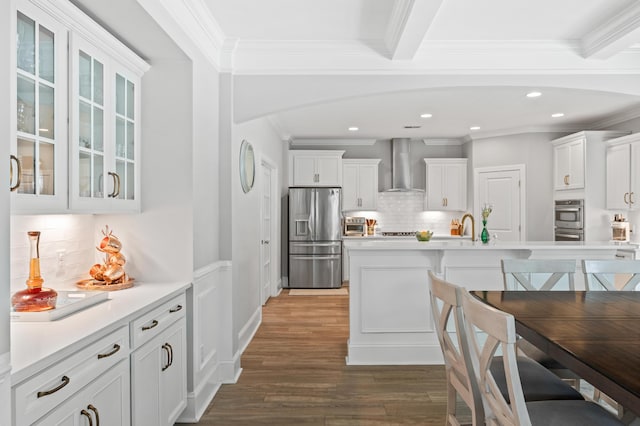 2802 Cavalcade Cir, Johns Island, SC 29455 - kitchen featuring stainless steel appliances, wall chimney exhaust hood, wood finished floors, decorative backsplash, and light countertops