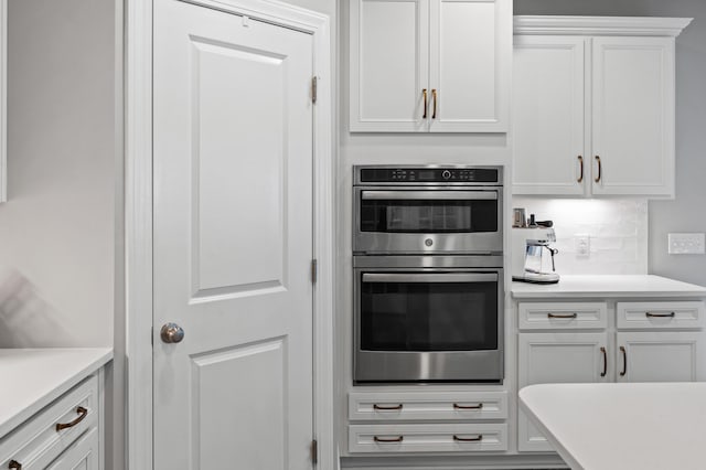 2802 Cavalcade Cir, Johns Island, SC 29455 - kitchen with stainless steel double oven, white cabinets, light countertops, and backsplash