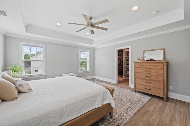 2802 Cavalcade Cir, Johns Island, SC 29455 - bedroom featuring a tray ceiling, light wood-style floors, a walk in closet, ornamental molding, and recessed lighting